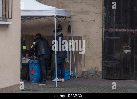 Biebesheim, Germany. 21st Feb, 2019. Criminal police officers (l) secure previously seized evidence in the backyard of a house near the railway station. Police searched several apartments of alleged Islamists in southern Hesse and North Rhine-Westphalia on Thursday morning. According to a spokeswoman for the public prosecutor's office in Frankfurt, the case is being investigated on suspicion of preparation for a serious violent act that would endanger the state. Credit: Boris Roessler/dpa - ATTENTION: Person was pixelated for legal reasons/dpa/Alamy Live News Stock Photo