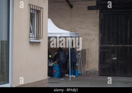 Biebesheim, Germany. 21st Feb, 2019. Criminal police officers (l) secure previously seized evidence in the backyard of a house near the railway station. Police searched several apartments of alleged Islamists in southern Hesse and North Rhine-Westphalia on Thursday morning. According to a spokeswoman for the public prosecutor's office in Frankfurt, the case is being investigated on suspicion of preparation for a serious violent act that would endanger the state. Credit: Boris Roessler/dpa - ATTENTION: Person was pixelated for legal reasons/dpa/Alamy Live News Stock Photo