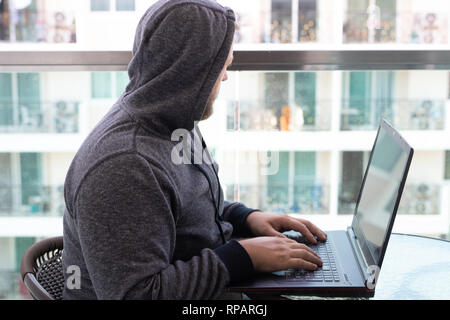 Cybercrime, hacking and technology concept - male hacker writing code or using computer virus program for cyber attack Stock Photo
