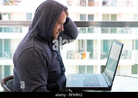 Cybercrime, hacking and technology concept - male hacker writing code or using computer virus program for cyber attack Stock Photo