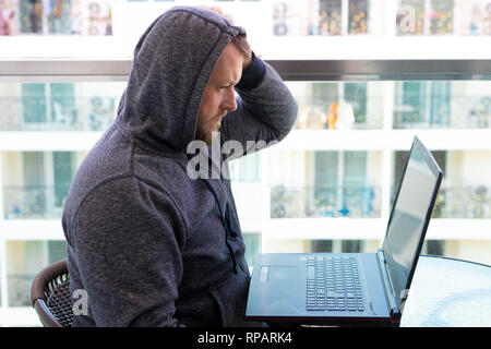 Cybercrime, hacking and technology concept - male hacker writing code or using computer virus program for cyber attack Stock Photo