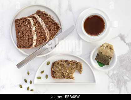 Homemade ryebread with pumpkin seed spread and a cup of green tea Stock Photo