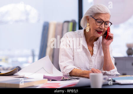 Enchanting well-groomed aging boss speaking on the phone in office. Stock Photo