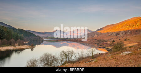 Scenic view of Snowdon Horseshoe mountains at sunrise, reflected in still lake water of Llynnau Mymbyr, Snowdonia National Park, North Wales, UK. Stock Photo