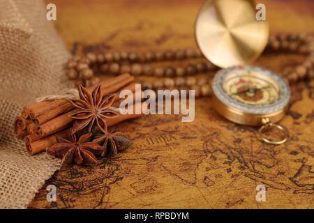 Vintage compass and cinnamon spices on a old world map - trade and explorer concept Stock Photo