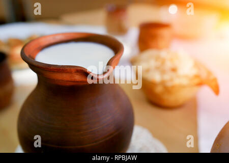 clay jug of milk on the table . Organic food Stock Photo