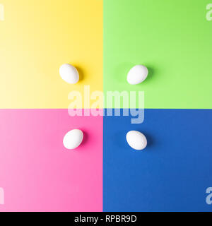 Four white eggs on colorful four-color background. Easter pop art pattern.  Stock Photo