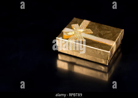 Golden jewellery box on a black glossy background Stock Photo