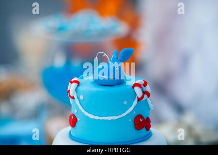 Huge blue and white birthday cake with sweet crab, fish, starfish and funny whale on the top. Summer season delicious on the party. Sea time theme on  Stock Photo