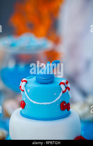 Huge blue and white birthday cake with sweet crab, fish, starfish and funny whale on the top. Summer season delicious on the party. Sea time theme on  Stock Photo