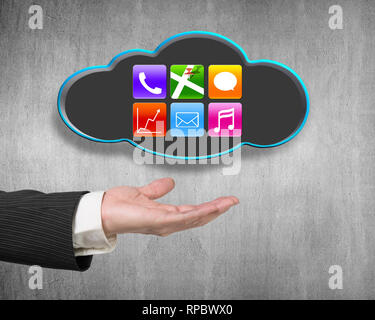 Male hand showing black cloud with colorful app icons on concrete wall background Stock Photo