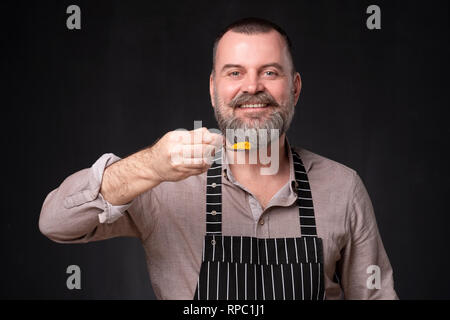 Europeam mature chef showing his favorite spice, orange turmeric Stock Photo