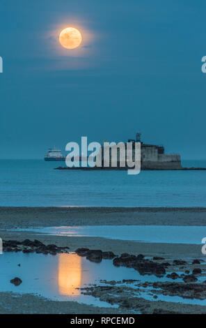 The full moon, the snow moon, and a super moon, rising over St Helens Fort, a Victorian Fort, ordered by Pamerstone defend the Solent. Stock Photo