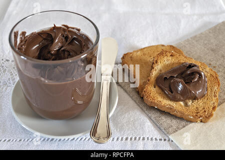 fette biscottate con crema di nocciole al cacao con bicchiere Stock Photo
