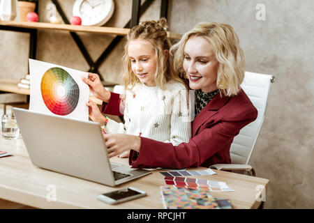 Smiling positive mother having mess on her office table Stock Photo