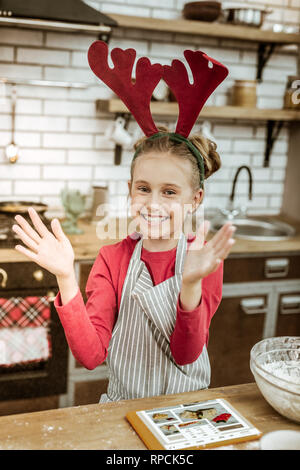 Smiling beaming woman wearing red dress and striped apron Stock Photo
