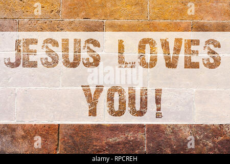 Text sign showing Jesus Loves You. Conceptual photo Believe in the Lord To have faith religious demonstrating Brick Wall art like Graffiti motivationa Stock Photo