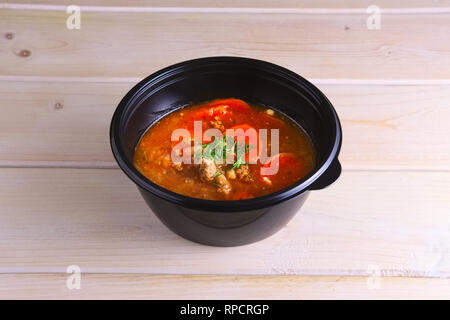 Sour cabbage beef soup with carrot and tomato in take away packaging Stock Photo
