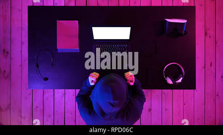 Top view. Lucky hacker won with his laptop. White Display. Professional shot in 4K resolution. 020. You can use it e.g. in your commercial video, busi Stock Photo