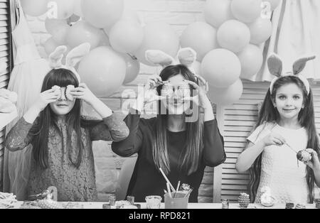 Mother and daughters are painting eggs Stock Photo