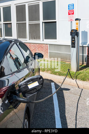 North Babylon, New York, USA - 16 June 2018: An electric car is plugged into a free charging station at a local town park. Stock Photo