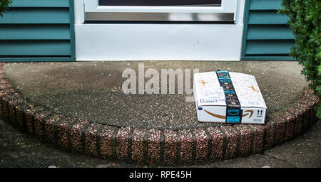 Babylon, New York, USA - 13 September 2018: A package is left on a front porch and is vulnerable to being stolen. Stock Photo