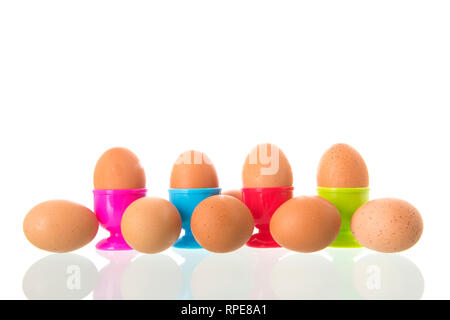 Colorful egg cups with eggs isolated over white background Stock Photo