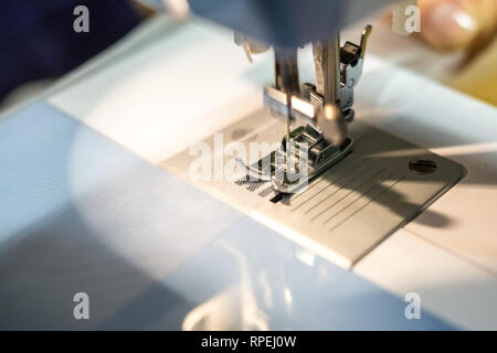 close up mechanism of sewing machine foot  with needle and thread Stock Photo