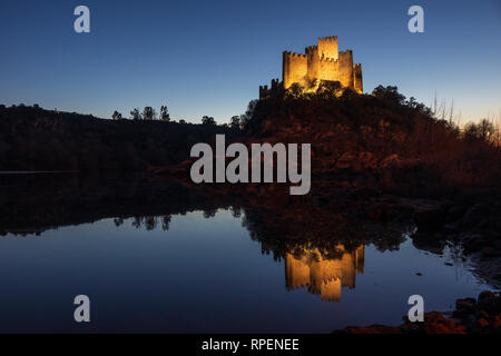 Almourol, Portugal - January 12, 2019: Almourol castle illuminated by artificial light at dusk with the reflection in the water of the Tagus river. Stock Photo