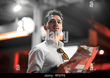 Attractive businessman checking his map while waiting for train in metro or subway on modern stylish platform. Concept of good city navigation. Search Stock Photo