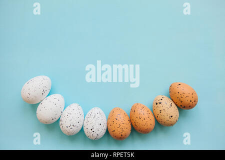 Set of colored eggs on a blue background. Festive Easter concept. Above there is a place for text. Stock Photo