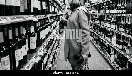 https://l450v.alamy.com/450v/rpexa4/strasbourg-france-dec-30-2017-elegant-french-woman-buying-diverse-alcoholic-drinks-wines-champagne-and-whiskey-in-wine-department-of-a-large-french-supermarket-black-and-white-image-rpexa4.jpg