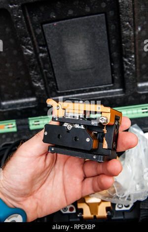 Male technician POV at high-precision optical fiber cleaver for cutting optical fiber very precisely during FTTH home and office - modern internet service provider using high-precision tool Stock Photo