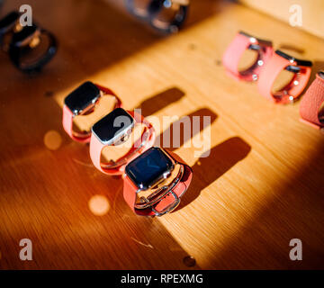 PARIS, FRANCE - OCT 26, 2018: Hero object of the latest Apple Watch Series 4 in Apple Store Computers rows of red bands and aluminum, steel and gold watches Stock Photo