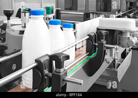 Plastic bottles on conveyor belt ready for pouring milk Stock Photo