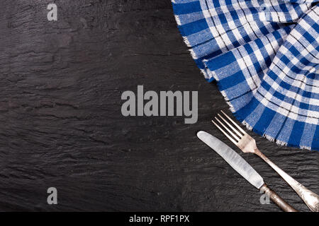 blue checkered tablecloth on the black stone table with copy space for your text. Top view Stock Photo