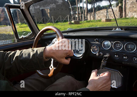 ROME - A man drives an oldtimer MG sportscar on the Appian way. Construction of the Appian way started in 312 BC. Stock Photo