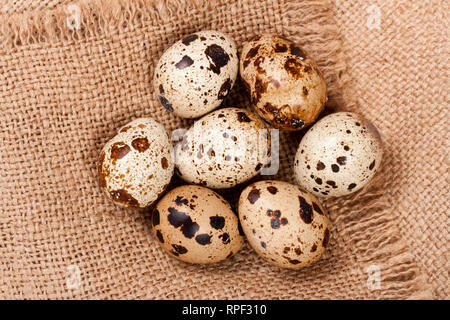 Several quail eggs on burlap. Close-up. Top view Stock Photo