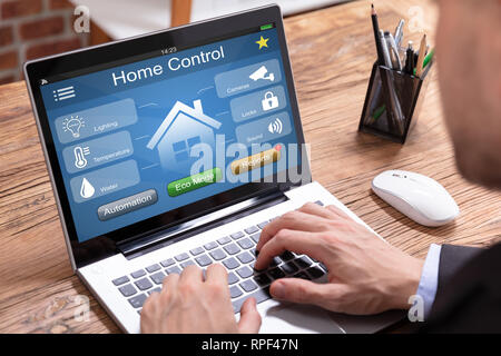 Person's Using Laptop With Home Control Application Stock Photo
