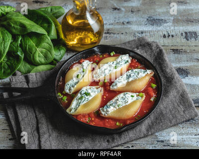 pasta conchiglioni stuffed spinach and cheese, tomato sauce cooked Stock Photo