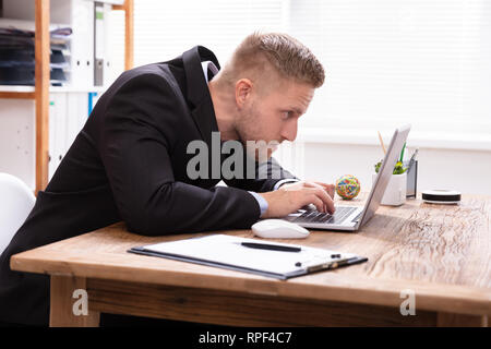 Concentrated Businessman Looking At Laptop Working In Office Stock Photo