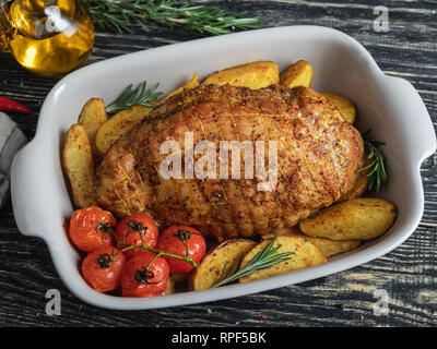 Roasted pork meat roulade, roll with potato and tomato in baking tray Stock Photo