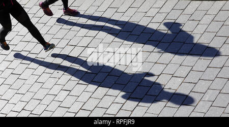 22 February 2019, Berlin: With bright sunshine and temperatures around two degrees Celsius, people jog along the Spree, casting their long shadows on the pavement. According to the meteorologists, the coming days will be very sunny again. Temperatures drop to minus eight degrees Celsius at night. Photo: Wolfgang Kumm/dpa Stock Photo