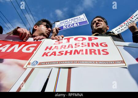 Srinagar, Kashmir. 22nd Feb 2019. A member of the Kashmir Chamber of Commerce & Industries (KCCI) seen holding a placard saying stop harassing kashmiris during the protest in Srinagar.Protests broke out in Srinagar against the many attacks on Kashmiri's in Jammu and other parts of the country following the militant attack on a paramilitary Central Reserve Police Force (CRPF) convoy in south Kashmir killing 40 troopers on Feb 14. Credit: Saqib Majeed/SOPA Images/ZUMA Wire/Alamy Live News