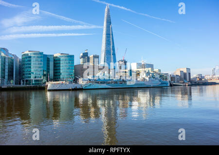 The battleship HMS Belfast moored on the river Thames at Southwark London with the Shard building  in the background on the London skyline Stock Photo