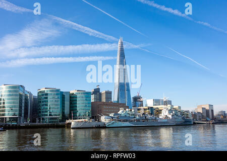 The battleship HMS Belfast moored on the river Thames at Southwark London with the Shard building  in the background on the London skyline Stock Photo