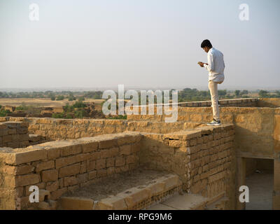 Tourist standing at an abandoned house, Kuldhara - an abandoned village in Jaisalmer, Jaisalmer, Rajasthan, India Stock Photo