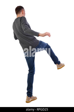 Back view man Balances waving his arms. Rear view people collection. backside view of person.  Isolated over white background. Man kicks forward. Stock Photo