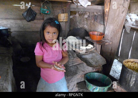 El Salvador  JDS projects in Jujutla.  Family of Alvaro Tejada (60), his wife Agripina Castillo (34) with their daughter Fatima Tejada (6), in village of Los Vasquez, Jujutla. In kitchen making tortillas with 'llorena' eco woodstove. Stock Photo