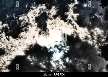 Clouds accenting eclipsing sun on stormy day Stock Photo